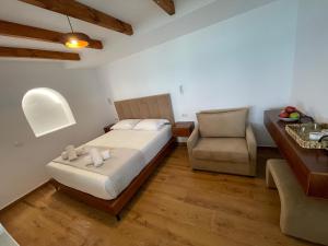 a small bedroom with a bed and a chair at Villa Scorpio in Qeparo