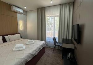 a hotel room with a bed and a television at Park Avenue Hotel in Taraz
