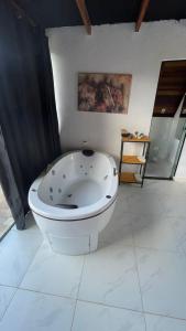 a white bath tub sitting in a room at Pousada Estrela Dalva in Piracaia
