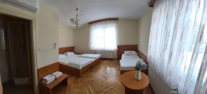 a room with two beds and a table and a window at Gostišče Krka in Znojile pri Krki