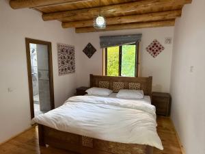 a bedroom with a large bed with white sheets at Nurata mountains Hayat guesthouse in Yukary-Ukhum