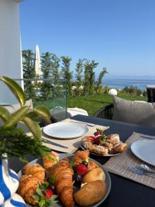 a table with plates of pastries and fruit on it at My Sea Lodge - Glaros Complex in Pefkochori