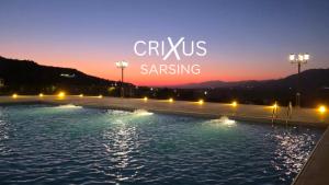 a sign that reads crisus sning at night at Crixus Hotels Sarsing in Sarsing