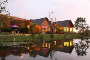 a wooden house with a pond in front of it at Green Forest Villa in Yilan City