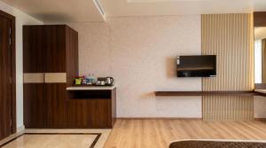a living room with a tv on the wall at The Lynora in Mysore