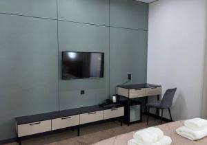 a bedroom with a tv and a bed and a chair at Park Avenue Hotel in Taraz +31 photos