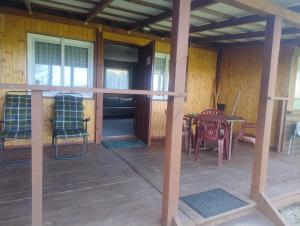a porch of a house with chairs and a table at Domek nad jeziorem -Mazury- Linia Brzegowa in Piotrowice +9 photos