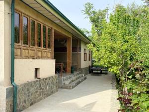 a building with a bench on the side of it at Nurata Eco Guesthouse in Yukary-Ukhum