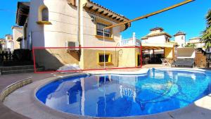 a large swimming pool in front of a house at Planta baja con piscina privada in Playas de Orihuela