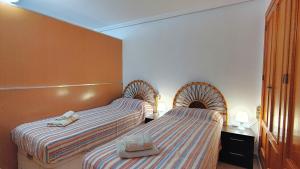 two beds in a hotel room with two beds at Planta baja con piscina privada in Playas de Orihuela +22 photos