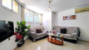 a living room with two chairs and a tv at Planta baja con piscina privada in Playas de Orihuela