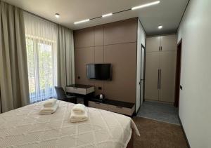 a bedroom with a bed with two towels on it at Park Avenue Hotel in Taraz