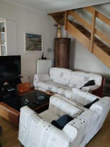 a living room with four white couches and a loft at Leo House in Selínia