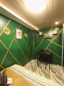 a bedroom with green walls and a bed and a table at Marcus Tiny House - Matcha in Cabanatuan City in Bangad +16 photos