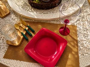 a red plate on a table with a glass at A Casa Piscina Quente até 50 Graus em Caldas Novas Com Sistema de Trocador de Calor e com Sauna e Ofurô Super Quente, Paradisiaca ll Com Roupa de Cama e Banho, Parcelamos em até 12x no Cartão de Crédito Sem Juros Aceitamos Pet in Caldas Novas