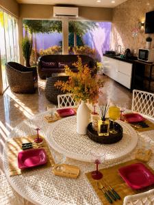 a dining room with a table with red plates and glasses at A Casa Piscina Quente até 50 Graus em Caldas Novas Com Sistema de Trocador de Calor e com Sauna e Ofurô Super Quente, Paradisiaca ll Com Roupa de Cama e Banho, Parcelamos em até 12x no Cartão de Crédito Sem Juros Aceitamos Pet in Caldas Novas