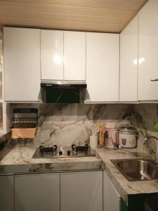 a kitchen with white cabinets and a sink at Marcus Tiny House - Matcha in Cabanatuan City in Bangad