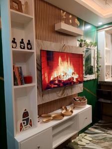 a fireplace in a living room with a tv at Marcus Tiny House - Matcha in Cabanatuan City in Bangad