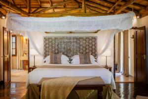 a bedroom with a large bed with a canopy at The Palms Zanzibar in Bwejuu +57 photos