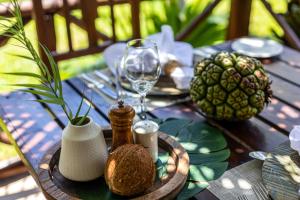 a wooden table with a glass of wine and a pineapple at The Palms Zanzibar in Bwejuu