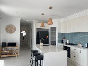 a kitchen with white cabinets and a white counter top at Coastal Calm Seascapes Halls Head in Falcon