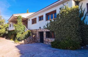 a white house with a stone wall at Casa Las Picoteras in La Estación