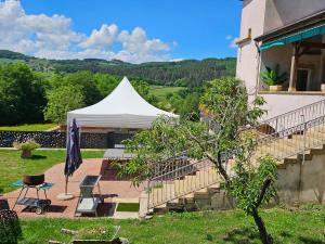 a white tent sitting next to a building at Gites de groupes Les Muriers in Bourgvilain