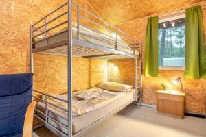 a bedroom with bunk beds in a room with green curtains at Bungalows im Grünen in Lychen