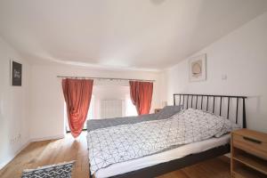 a bedroom with a bed and a window with red curtains at Apartamenty Złotoryja Silver 2 in Złotoryja
