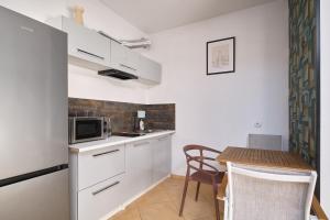 a small kitchen with a table and a microwave at Apartamenty Złotoryja Silver 2 in Złotoryja