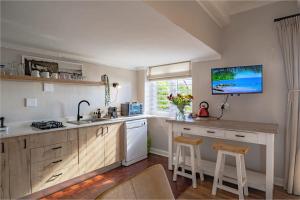 a kitchen with a sink and a counter with a stove at Sunny Cove Stays in Fish Hoek
