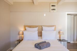 a bedroom with a bed with two pillows on it at Sunny Cove Stays in Fish Hoek
