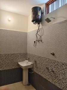 a bathroom with a sink and a tv on the wall at HIMALAYAN ESCAPE HOMESTAy in Sari
