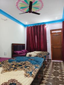 a bedroom with two beds and a ceiling fan at HIMALAYAN ESCAPE HOMESTAy in Sari +14 photos