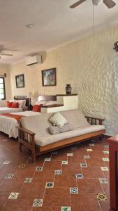 ein großes Schlafzimmer mit zwei Betten und einer Wand in der Unterkunft Hotel Casa el Moro in Puerto Morelos
