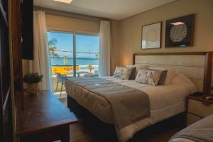 a bedroom with a bed with a view of the ocean at Hotel VillaReal Charme in Guaratuba +68 photos