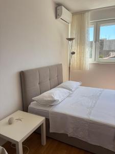 a bedroom with a bed and a table and a window at Charming studio with river view in Omiš