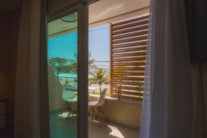 a room with a balcony with a view of the ocean at Hotel VillaReal Charme in Guaratuba
