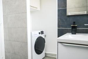 a bathroom with a washing machine and a sink at Le KA NOE in Vaires-sur-Marne