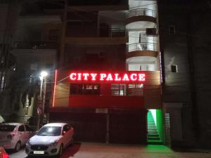 a city palace sign on the side of a building at night at City Palace in Zirakpur +16 photos