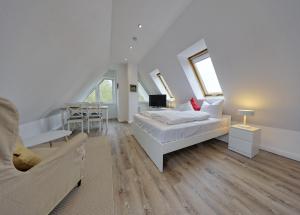 a white bedroom with a bed and a couch at Landhaus Dreesen in Timmendorfer Strand