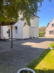 a courtyard with a building and a tree at Güden Pearl Bhaven Deck 6 ,Exklusive große Wohnung,Hochwertige Ausstattung,Privatparkplatz & Carport,Großer Garten mit Gartenhaus,Langzeitaufenthalt in Bremerhaven