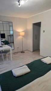a room with a bed and a table and a lamp at Pico Bello Płock in Płock