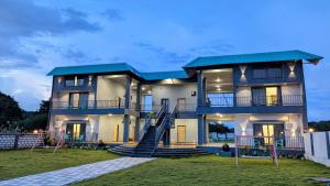 a large house with stairs in front of it at Sylvara Resort in Sasan Gir