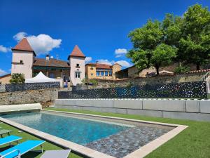 a swimming pool in front of a house at Gites de groupes Les Muriers in Bourgvilain