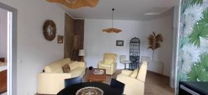a living room with white chairs and a table at L escapade de la voie douce in Le Cheylard +1 photo