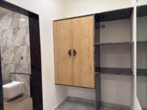a bathroom with a wooden cabinet and a toilet at Sylvara Resort in Sasan Gir +25 photos
