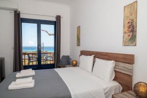 a bedroom with a bed with a view of the ocean at Adam in Falasarna