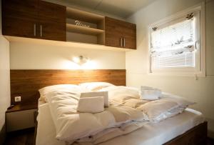 a large bed with white sheets in a room at Apartment Forstsee Ruhepol in Techelsberg am Worthersee