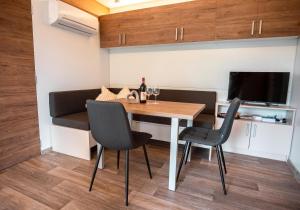 a dining room with a table and chairs and a television at Apartment Forstsee Ruhepol in Techelsberg am Worthersee